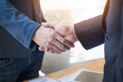 Deux hommes d'affaires confiants se serrant la main lors d'une réunion au bureau, le succès, le traitement, le salut et le concept de partenaire